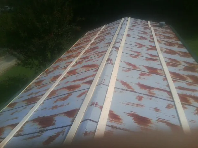 Rusted metal roof panels with new wood purlins before replacement — Storm Damage Roof Repair in Ronco by Roofing Brothers
