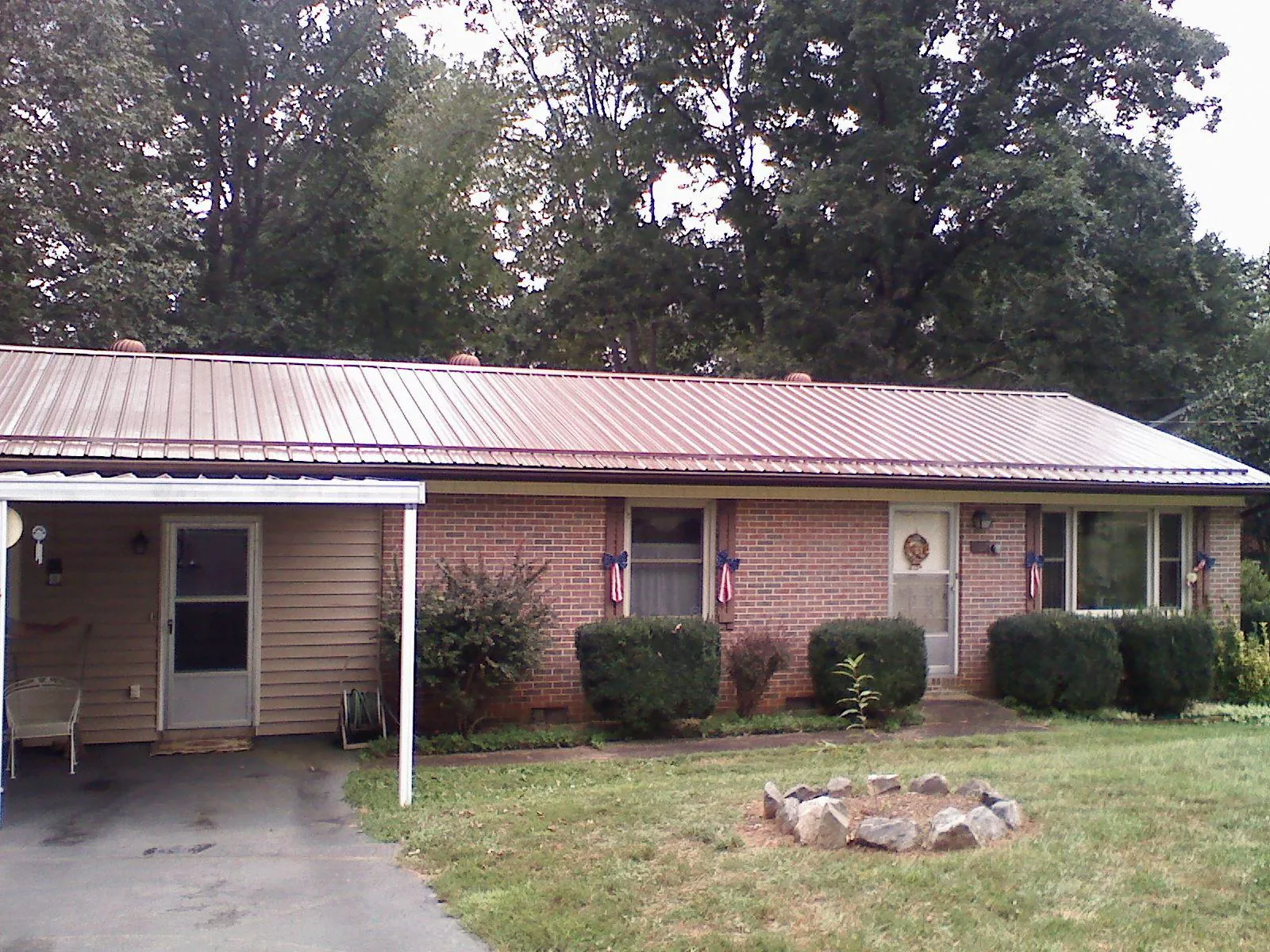 Bronze metal roof and carport on a brick ranch home — Roof Repair work by our crew in Ronco